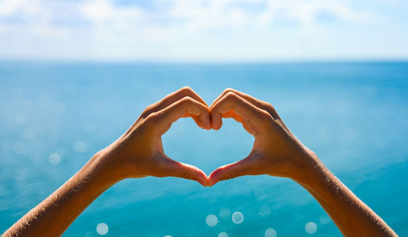 zwei-hände-formen-ein-herz-vor-blaem-meer