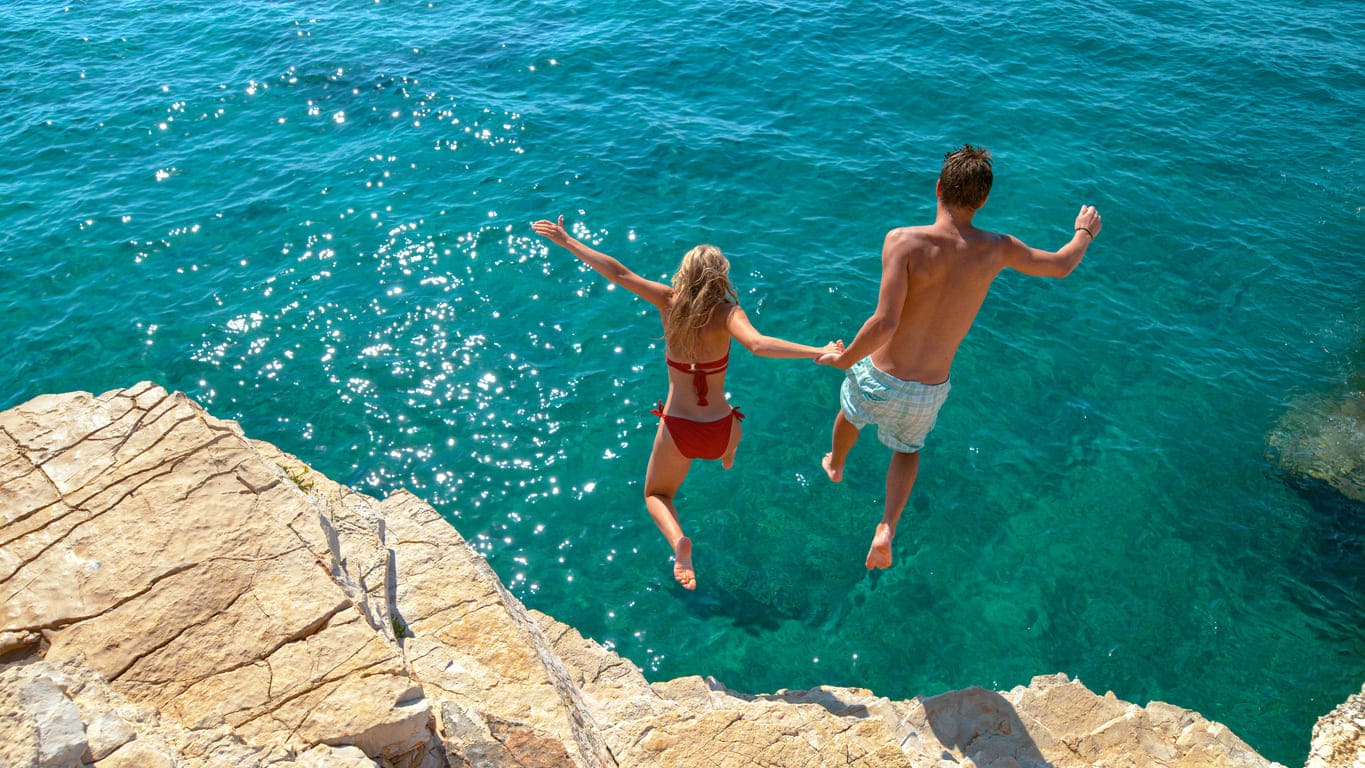 Ein Pärchen springt ins Meer