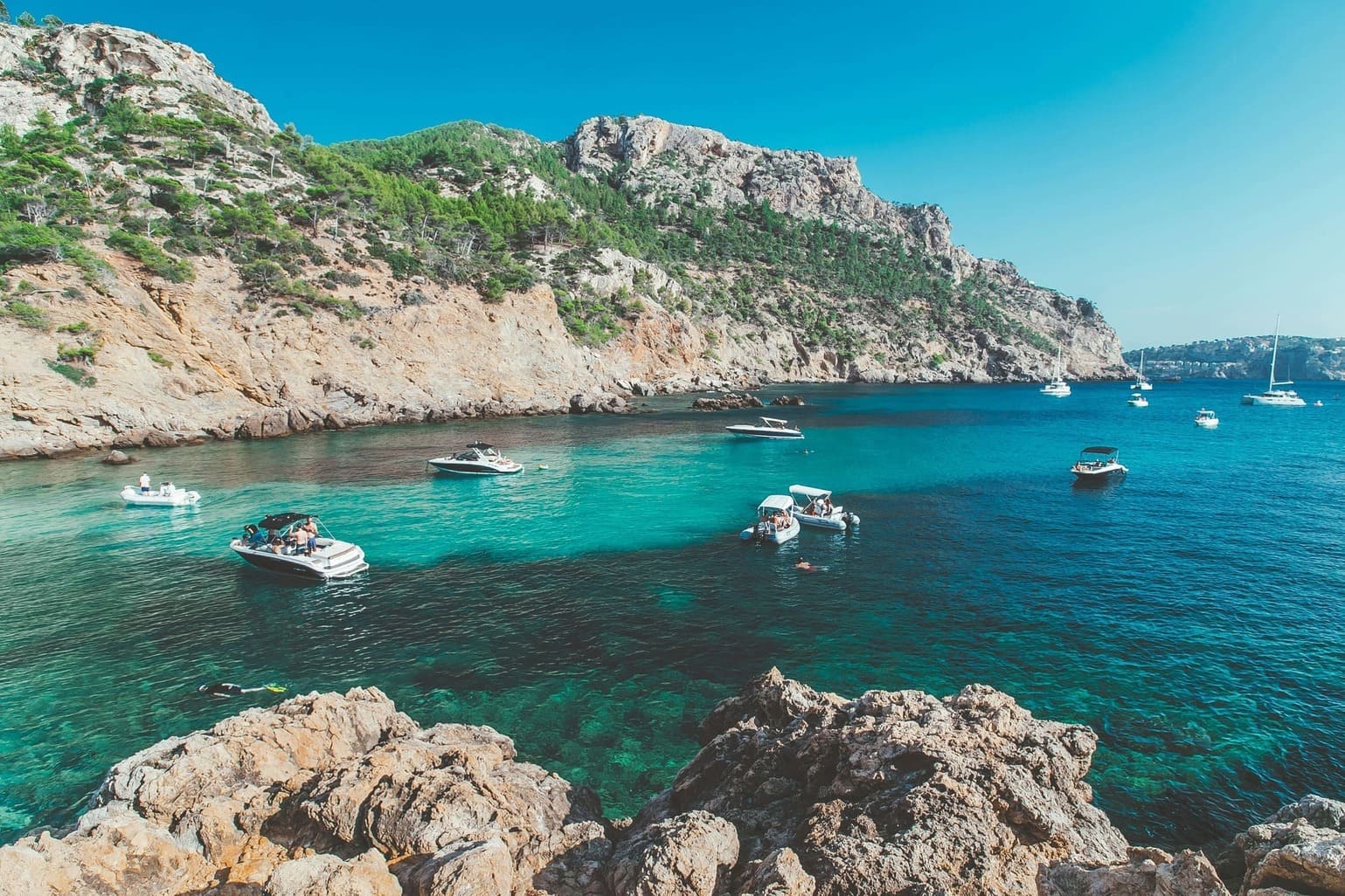 Kleine Felsenbucht mit blauem Meer und Booten